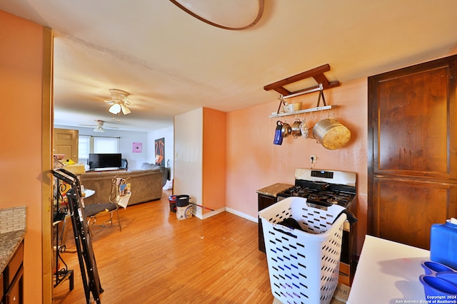 kitchen featuring baseboards, light wood-style floors, and ceiling fan