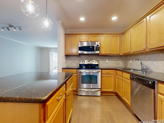 kitchen featuring a kitchen island, light hardwood / wood-style flooring, crown molding, stainless steel appliances, and sink