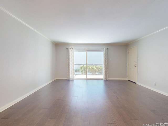 spare room with ornamental molding and dark hardwood / wood-style flooring