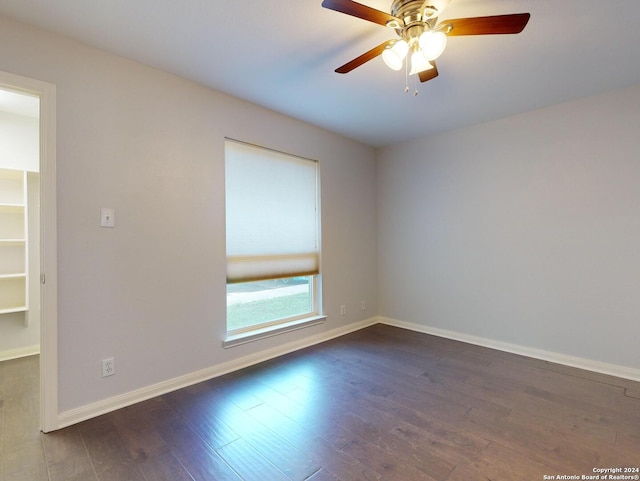 empty room with dark hardwood / wood-style flooring and ceiling fan