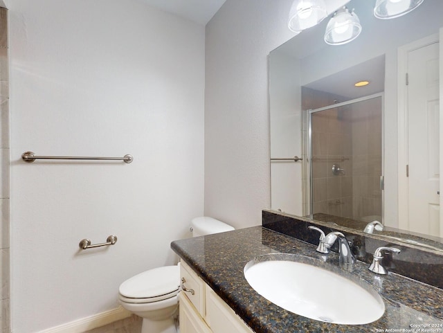 bathroom with vanity, toilet, and a shower with shower door