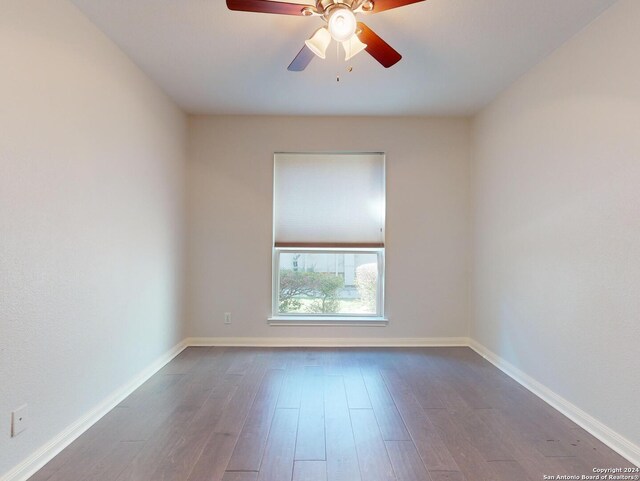 empty room with dark wood-type flooring and ceiling fan