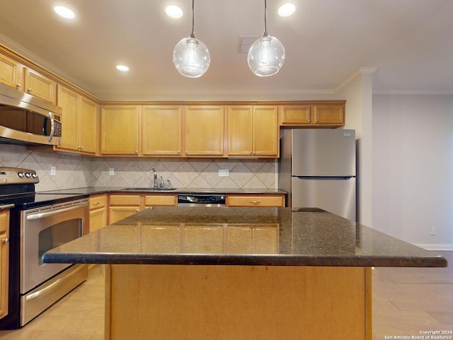 kitchen featuring a kitchen island, decorative light fixtures, appliances with stainless steel finishes, sink, and dark stone counters