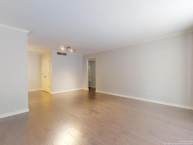 empty room featuring ornamental molding and wood-type flooring