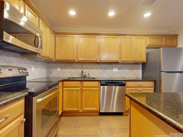 kitchen with crown molding, tasteful backsplash, light hardwood / wood-style flooring, stainless steel appliances, and sink