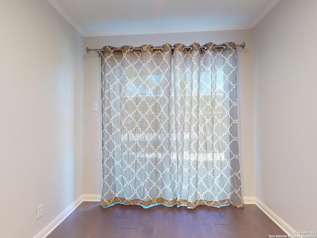 empty room featuring crown molding and dark hardwood / wood-style floors