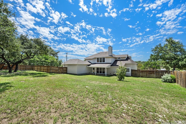 back of house featuring a lawn