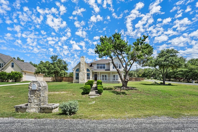 view of front of house with a garage, covered porch, and a front lawn