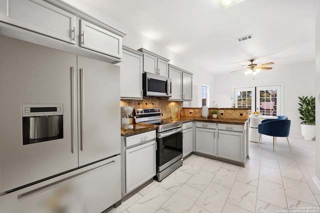 kitchen with ceiling fan, french doors, kitchen peninsula, decorative backsplash, and appliances with stainless steel finishes