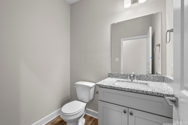 bathroom featuring hardwood / wood-style floors, toilet, and vanity