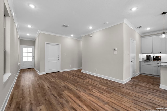 unfurnished living room featuring ornamental molding and dark hardwood / wood-style flooring