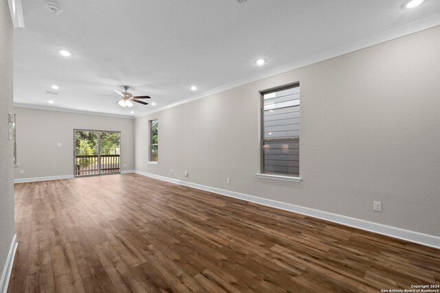 unfurnished living room featuring crown molding, ceiling fan, and dark hardwood / wood-style floors