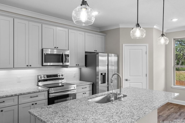 kitchen with a kitchen island with sink, pendant lighting, stainless steel appliances, and dark wood-type flooring