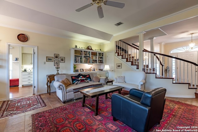 tiled living room featuring crown molding, ornate columns, and ceiling fan