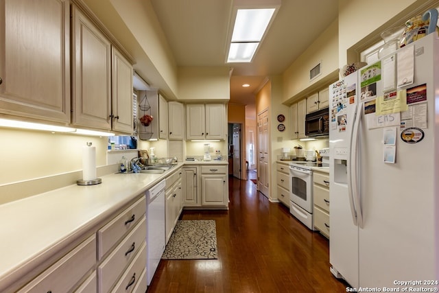 kitchen with dark wood-type flooring, white appliances, and sink