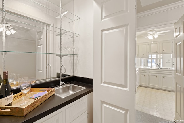 interior space featuring ornamental molding, vanity, and ceiling fan