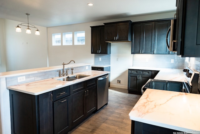 kitchen with appliances with stainless steel finishes, dark hardwood / wood-style flooring, tasteful backsplash, and sink