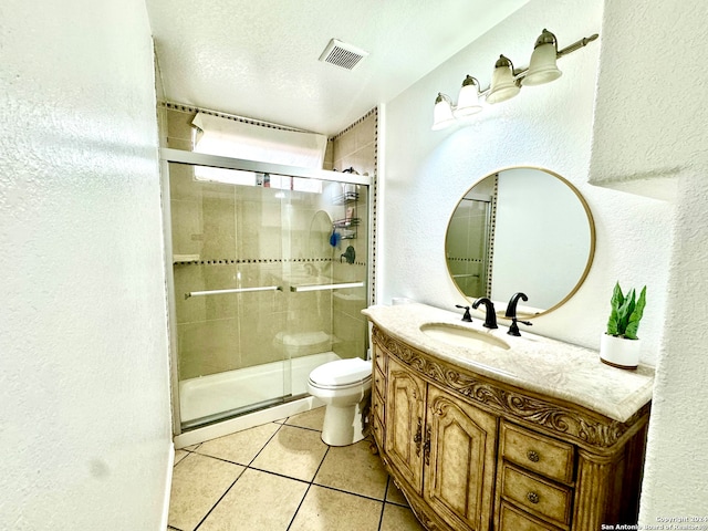 bathroom featuring a textured ceiling, vanity, a shower with shower door, toilet, and tile patterned floors