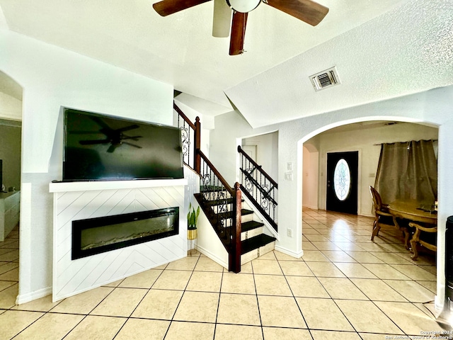 interior space featuring tile patterned floors, ceiling fan, and a textured ceiling