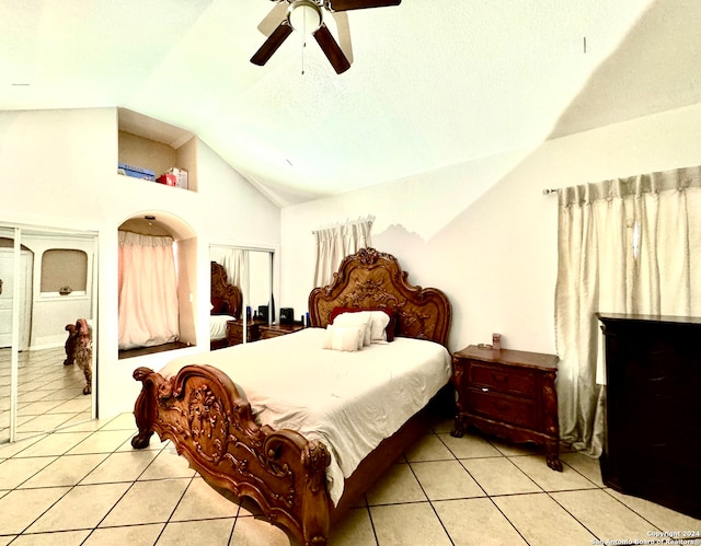 bedroom with lofted ceiling, light tile patterned floors, ceiling fan, and a textured ceiling