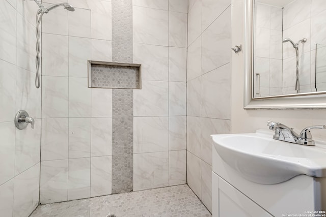 bathroom with tiled shower and vanity