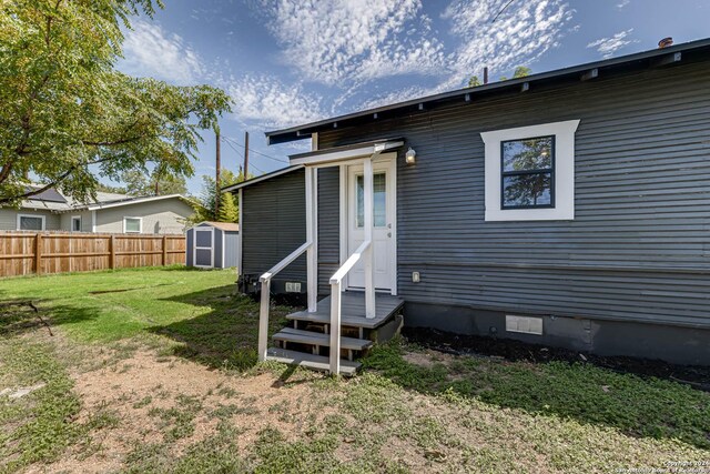 back of property featuring a yard and a shed