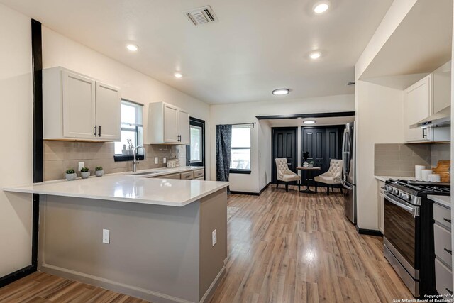 kitchen featuring stainless steel refrigerator with ice dispenser, plenty of natural light, kitchen peninsula, and wine cooler