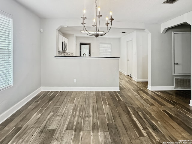 interior space featuring dark wood-type flooring and an inviting chandelier