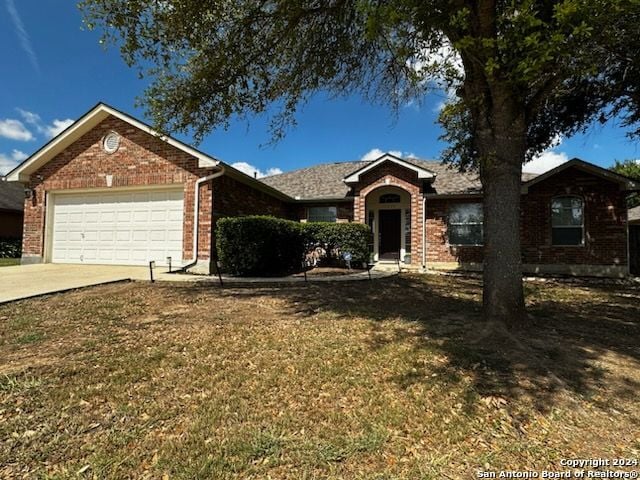 ranch-style home with concrete driveway, a garage, brick siding, and a front lawn