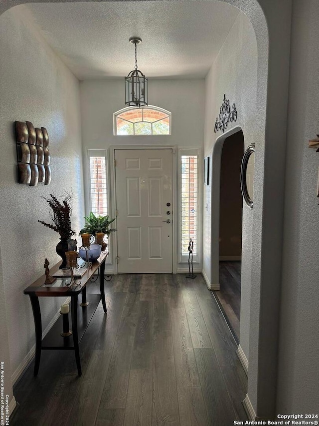 entryway featuring dark wood-type flooring and a textured ceiling