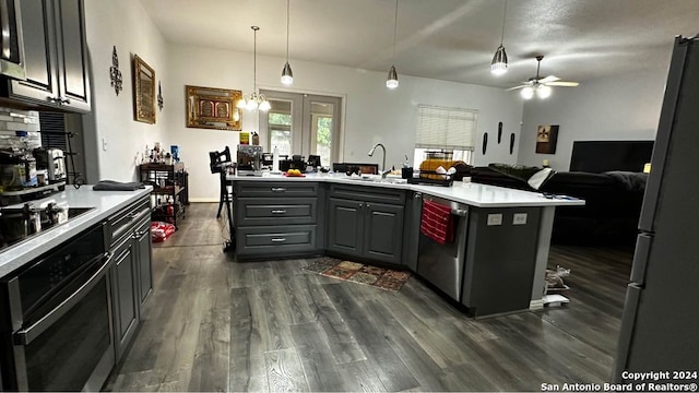 kitchen featuring oven, a sink, dark wood finished floors, freestanding refrigerator, and light countertops