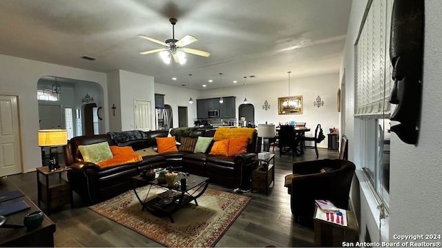 living area with visible vents, arched walkways, ceiling fan, and dark wood-style flooring