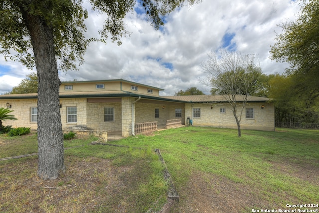 rear view of property with a lawn