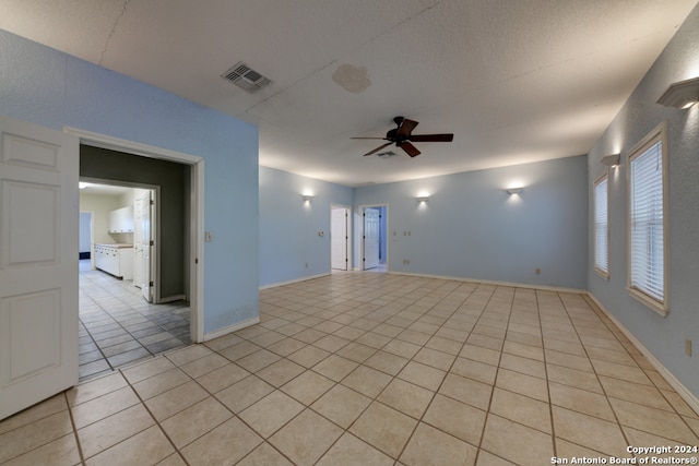 unfurnished room featuring ceiling fan, a textured ceiling, and light tile patterned floors