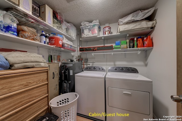 laundry room with washer and clothes dryer, a textured ceiling, and water heater