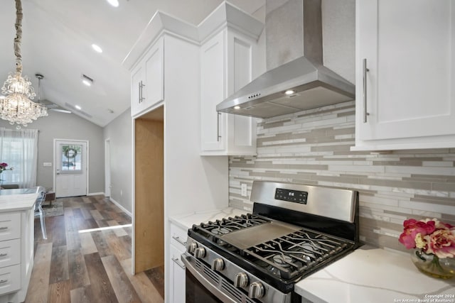 kitchen featuring gas stove, wall chimney exhaust hood, and white cabinetry