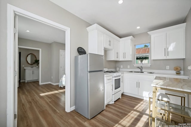 kitchen with stainless steel fridge, dark hardwood / wood-style floors, white gas stove, and sink