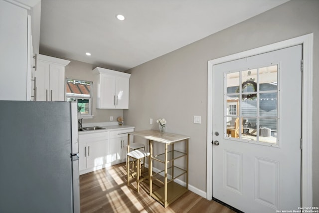 interior space featuring dark wood-type flooring, white cabinetry, stainless steel refrigerator, and sink