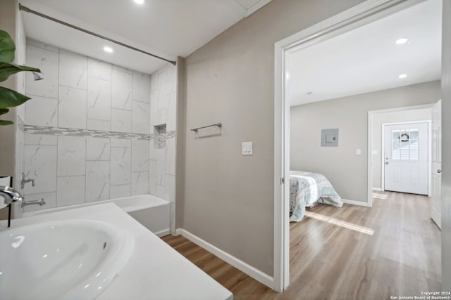 bathroom with separate shower and tub, sink, and hardwood / wood-style flooring