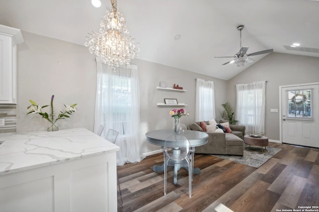 living room featuring lofted ceiling, ceiling fan with notable chandelier, and hardwood / wood-style flooring