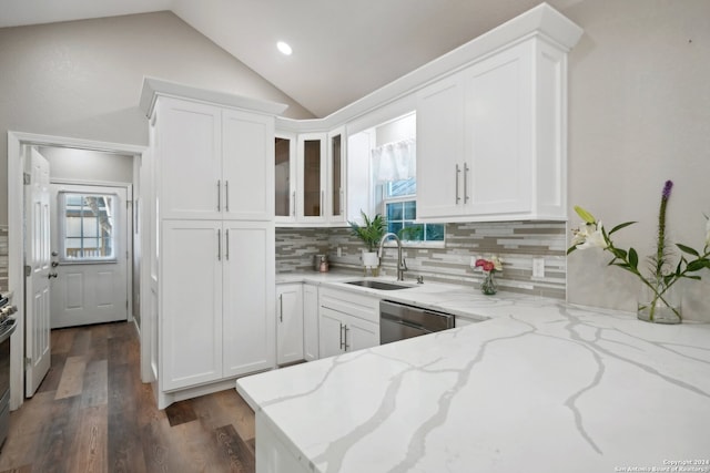 kitchen featuring light stone counters, sink, decorative backsplash, lofted ceiling, and white cabinets