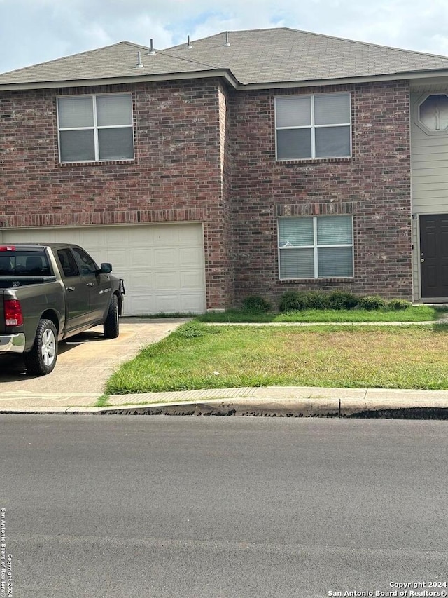 view of front of home with a garage and a front lawn