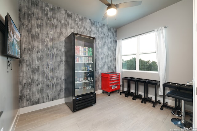 misc room featuring light wood-type flooring, ceiling fan, and beverage cooler