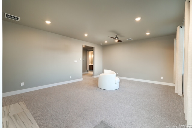 empty room featuring ceiling fan and light carpet