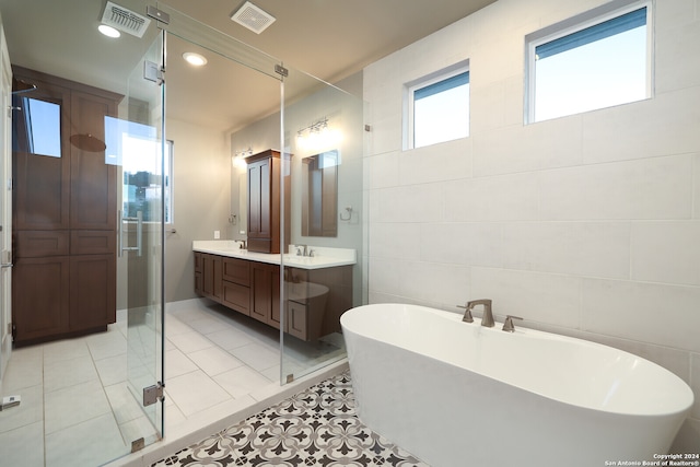 bathroom featuring vanity, tile walls, tile patterned floors, and plus walk in shower