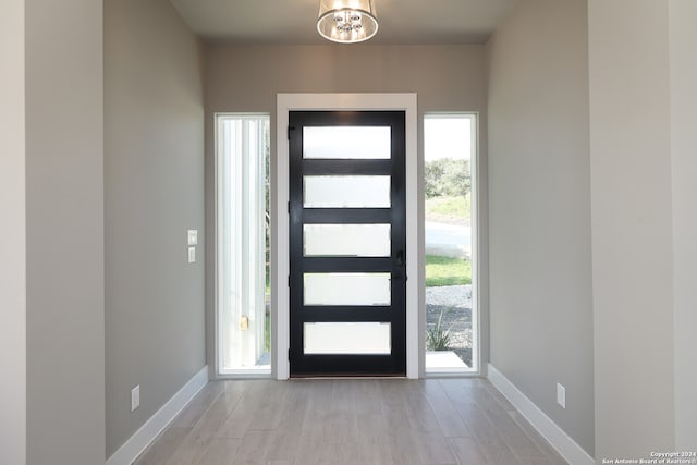 foyer featuring light hardwood / wood-style floors and a notable chandelier