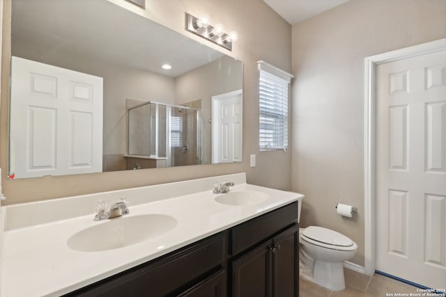 bathroom with tile patterned flooring, vanity, toilet, and an enclosed shower