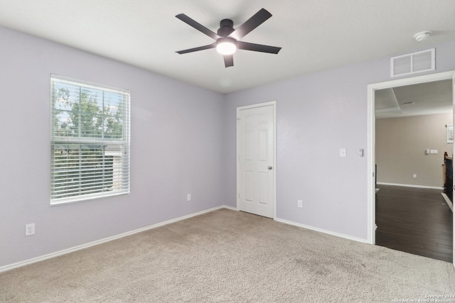 unfurnished room with ceiling fan and carpet