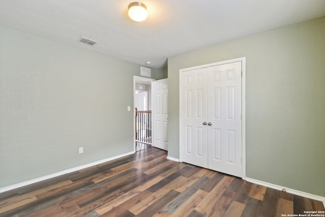 unfurnished bedroom with a closet and dark hardwood / wood-style floors