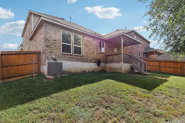 rear view of house featuring a yard and central AC